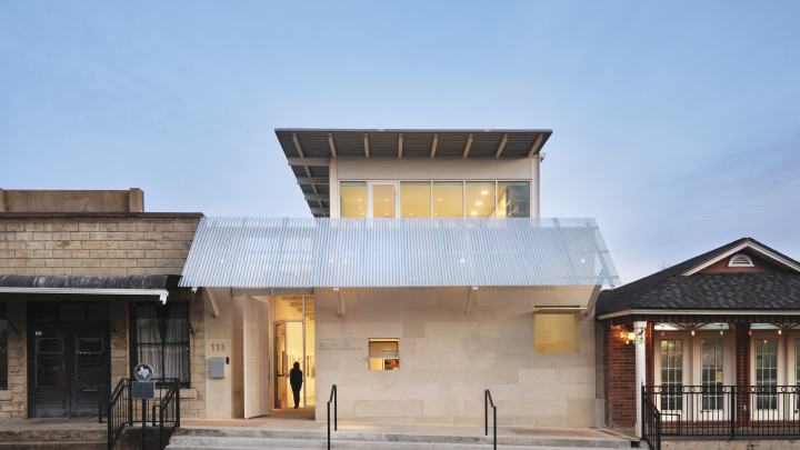 A beautiful modern building sits within the classic architecture of Marble Falls' main street at dusk.