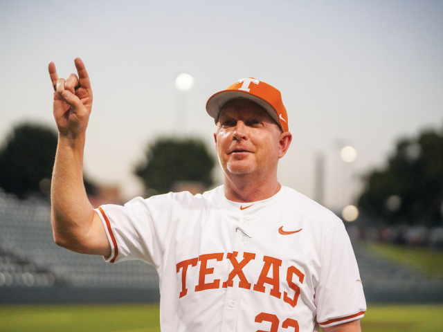 Coach Schlossnagle using the Hook 'Em Horns sign at the UFCU Disch-Falk Field