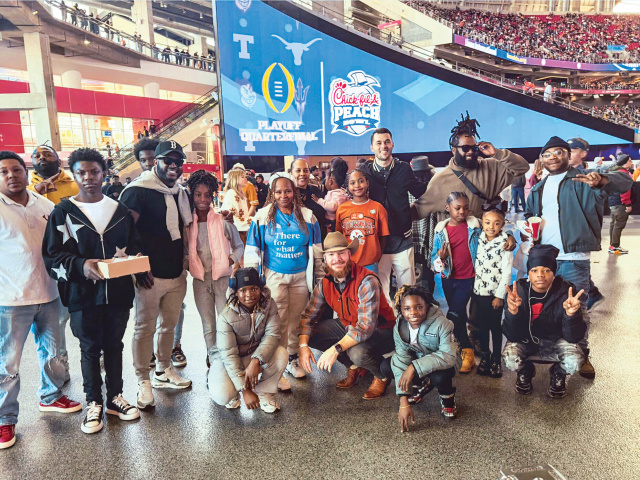 A group of students poses from inside the stadium at the Chick-fil-a Peach Bowl in Atlanta.