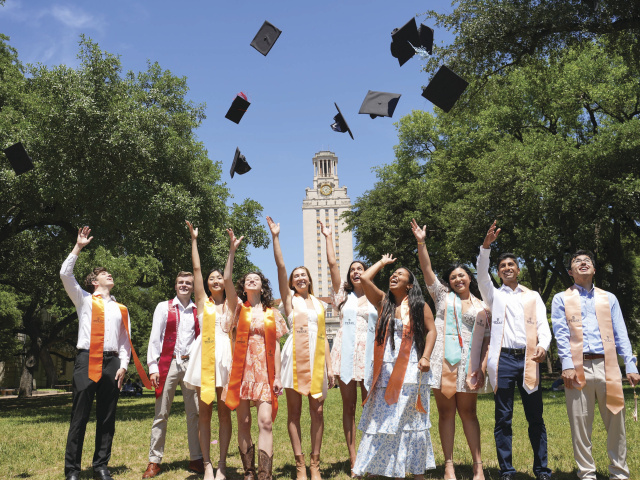 Graduates of 2024 throwing up their caps in front of the tower