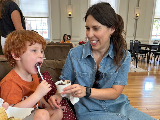 A kid eating dessert along with a friend