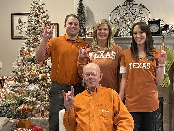 Family of Longhorns in front of a Christmas tree.