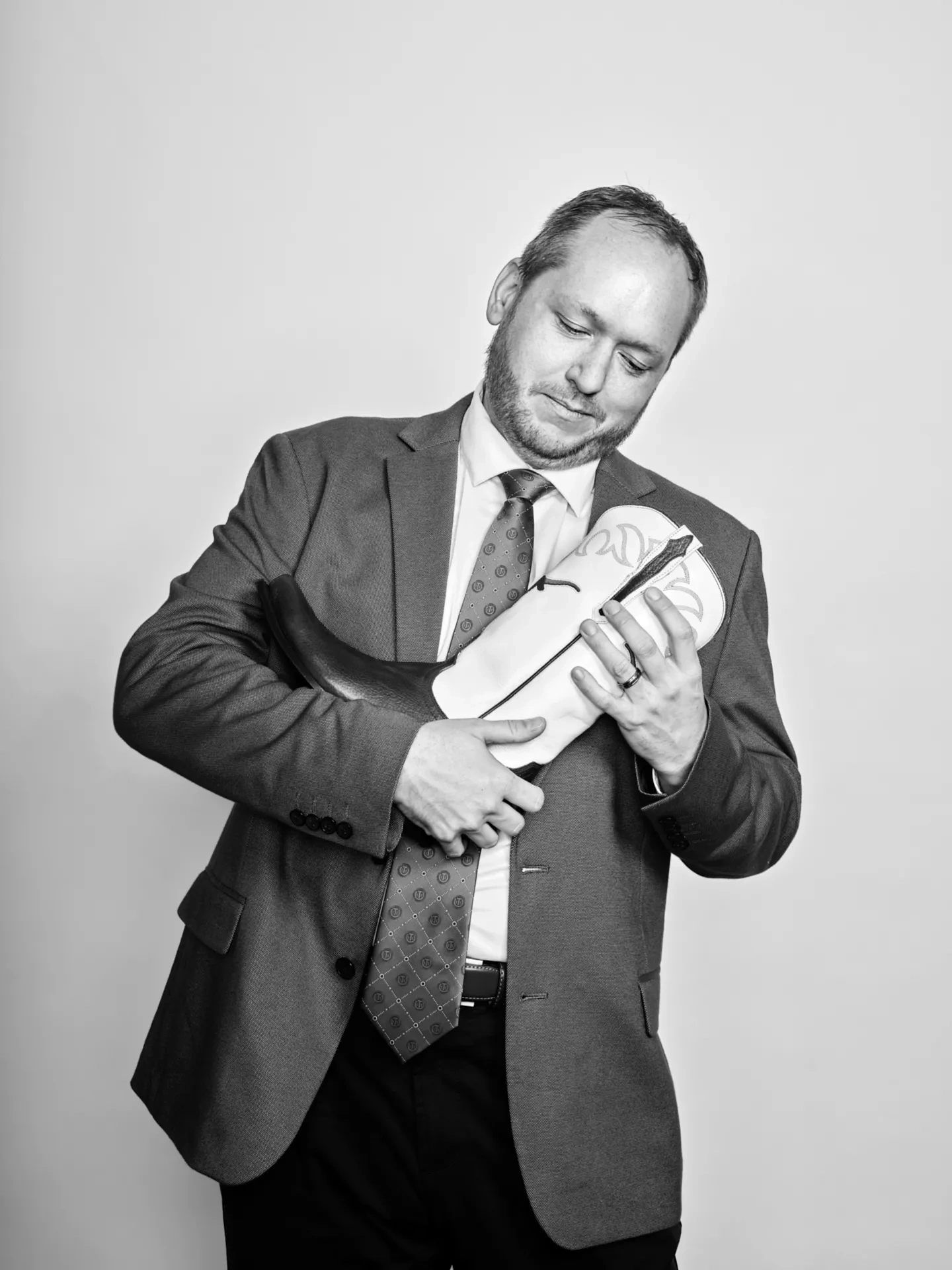 A man cradles a boot, staring down at it.