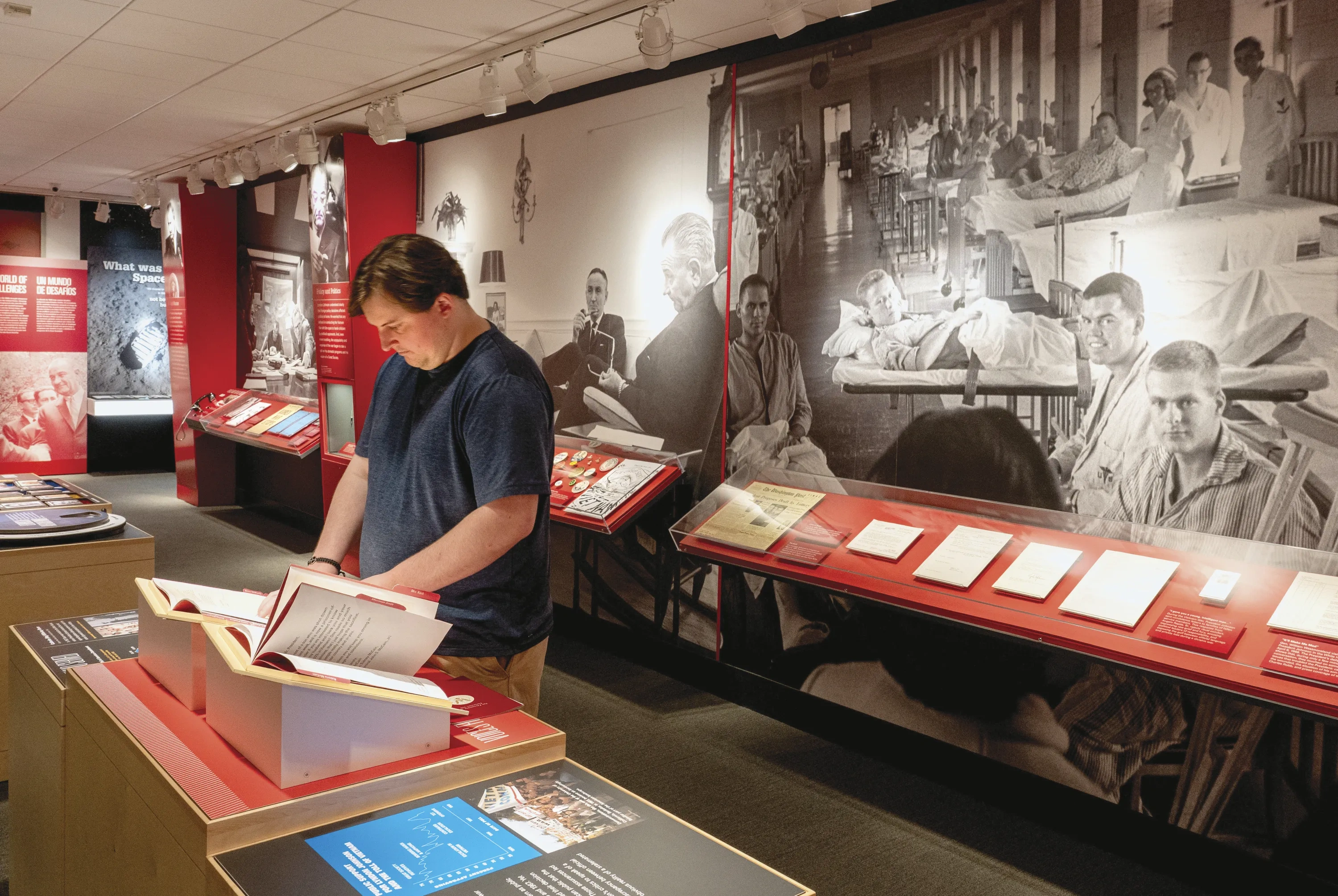 A visitor at the LBJ Library flips through a book on display.