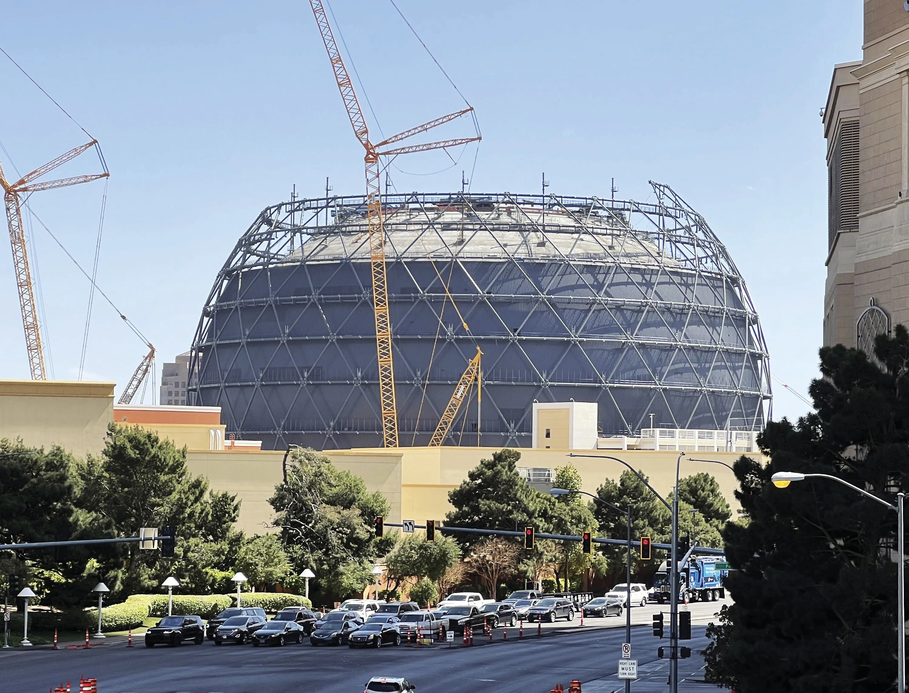 The Las Vegas Sphere under construction, surrounded by cranes and without a full top.