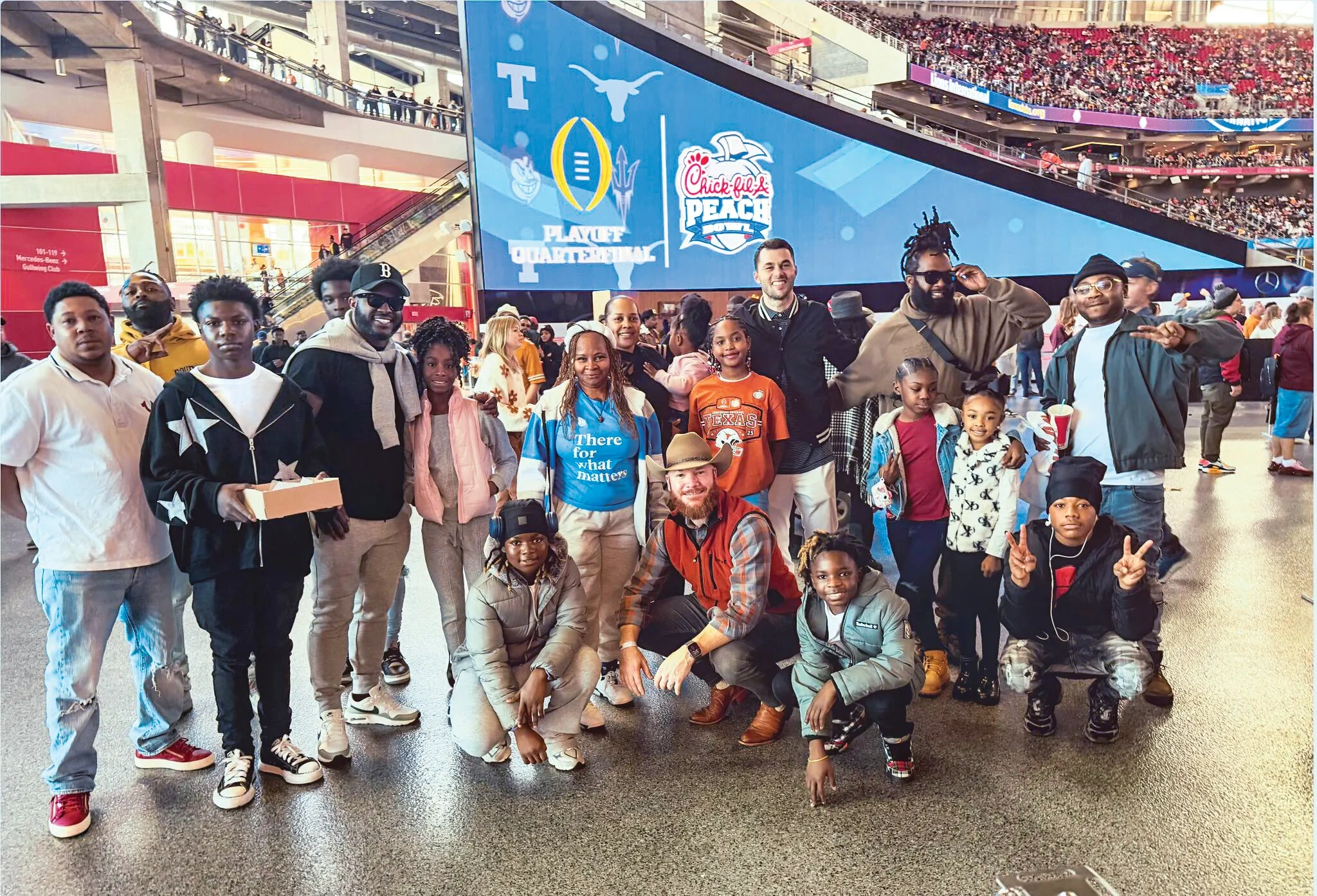 A group of students poses from inside the stadium at the Chick-fil-a Peach Bowl in Atlanta.