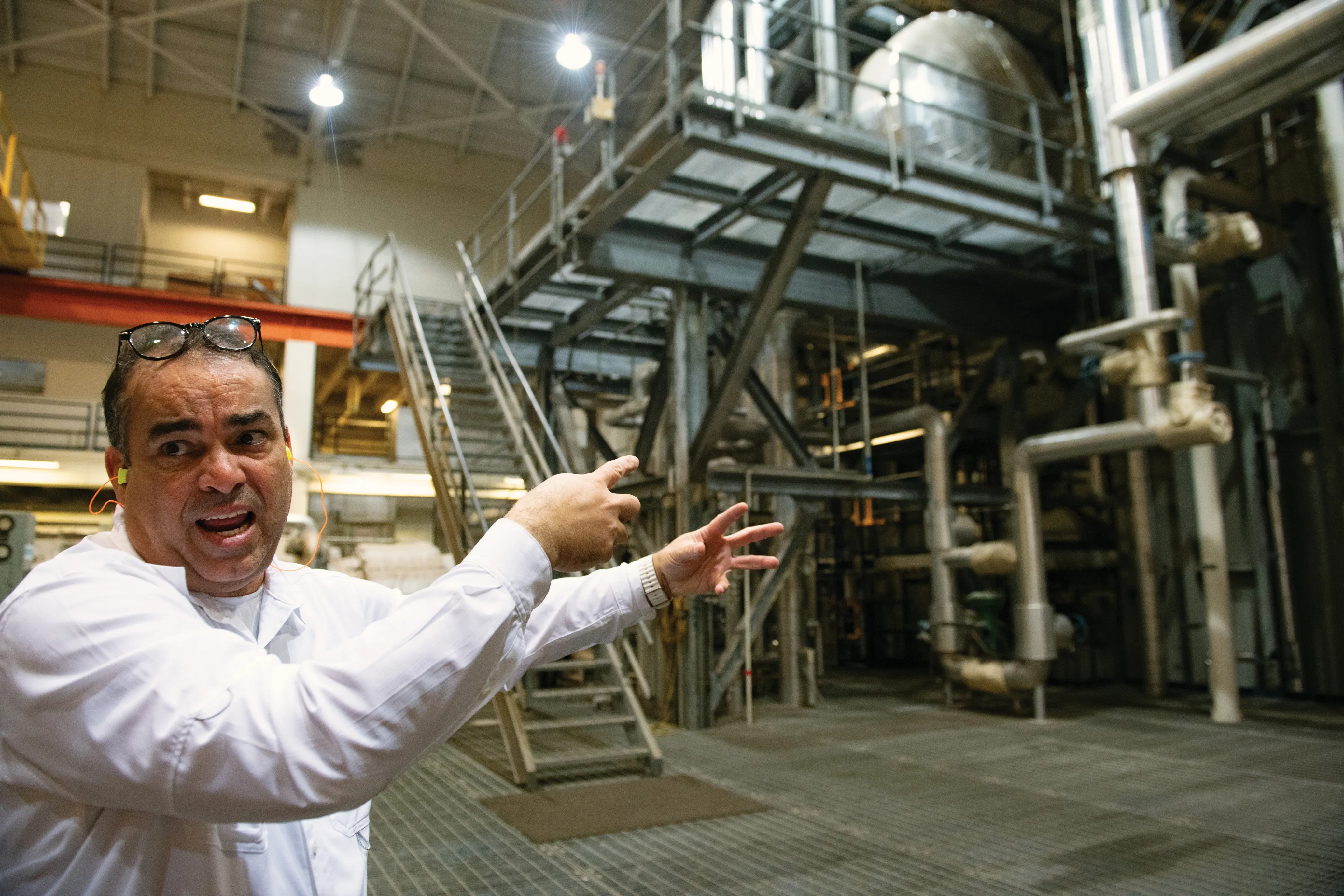 A man gestures to generators inside a power plant.