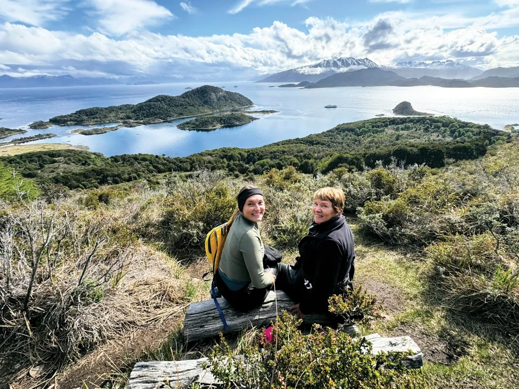 Two women smile over their shoulders.